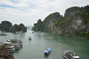 Barcos de crucero navegando entre las formaciones kársticas de la Bahía de Ha Long, Vietnam