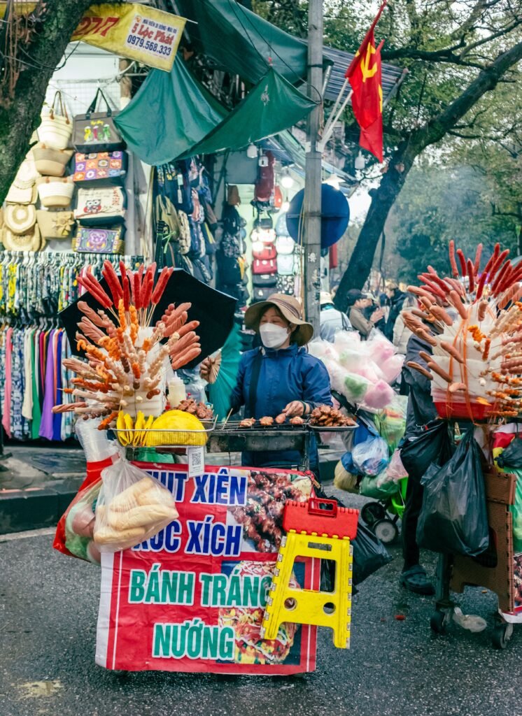 Puesto de comida callejera con banderas en una calle de Vietnam