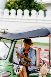 Viajera usando el móvil dentro de un tuk-tuk